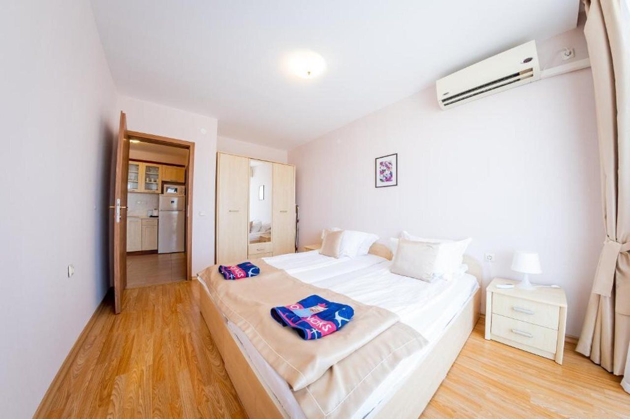 A bedroom with a bed, bedside table, and an air conditioning unit.