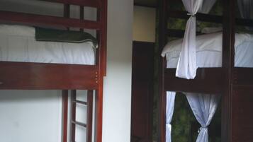 A room with bunk beds, a wooden ceiling, and a tiled floor.