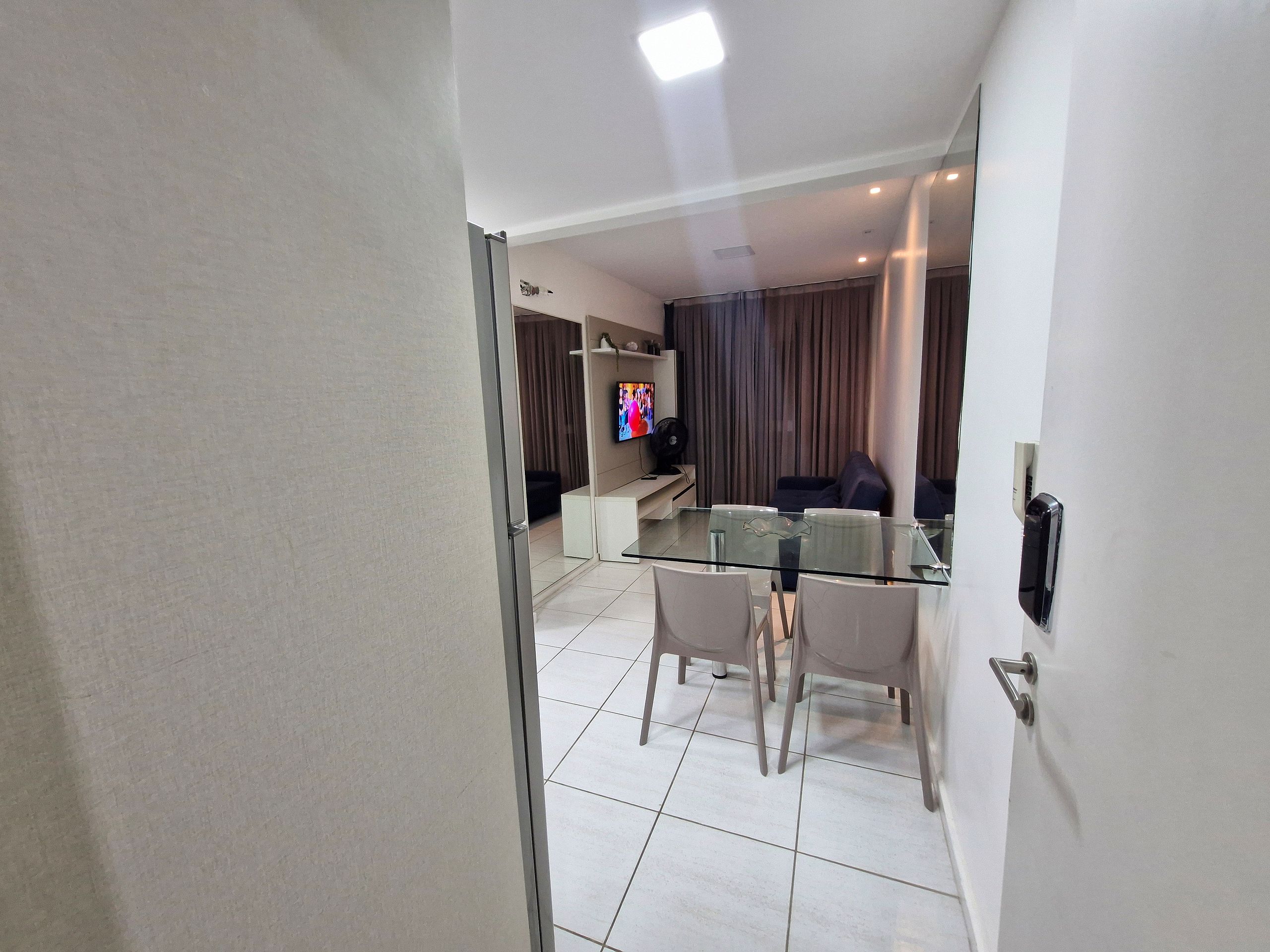 Una sala moderna con una mesa de vidrio, un sofá y un televisor.