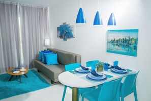 En matplats med ett runt bord, blå stolar och en soffa med blå kuddar.