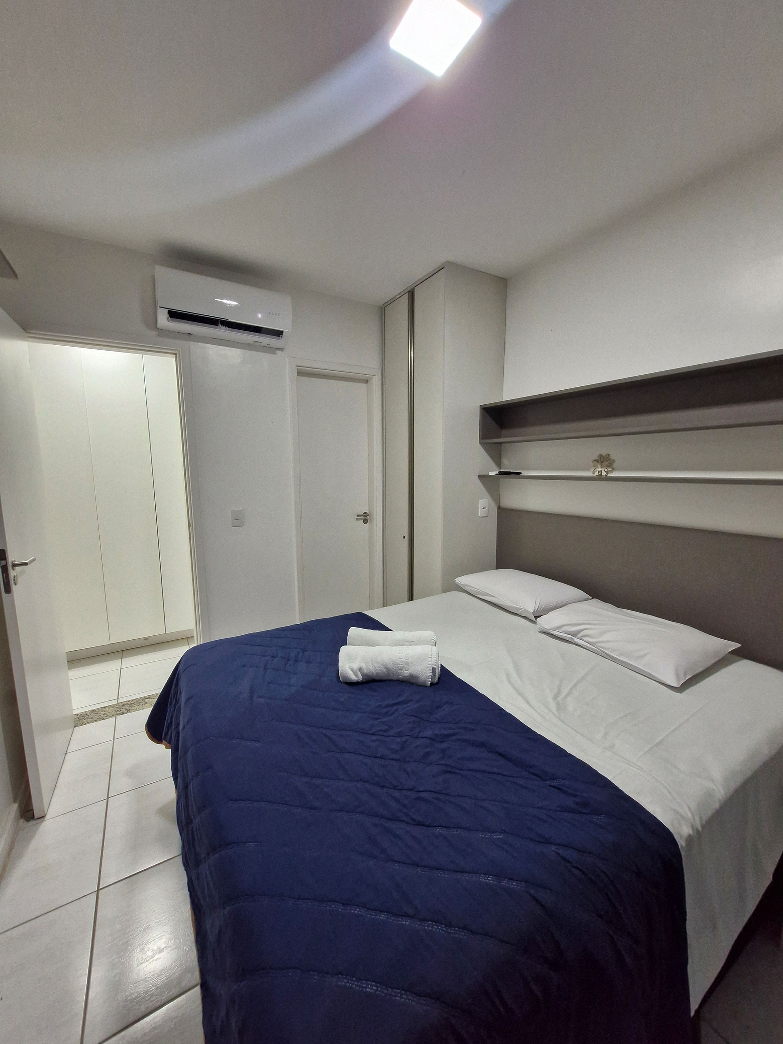Ein Hotelzimmer mit einem Bett, einem Kleiderschrank und einer Klimaanlage.
