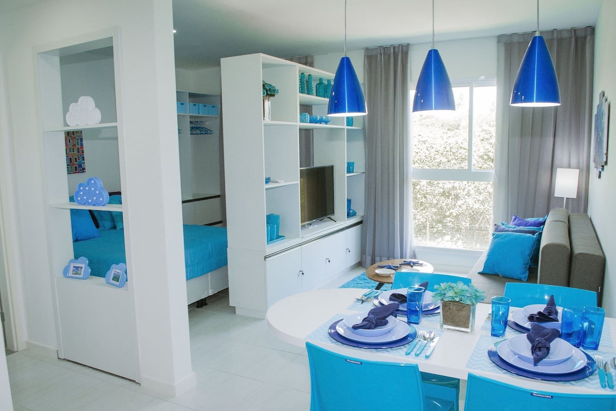 Une chambre d’hôtel moderne dotée d’un coin repas, d’une télévision et d’un canapé.