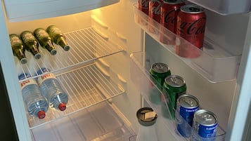 An open refrigerator with shelves containing beverages and a milk carton.