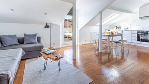 Moderni loft-tyylinen huoneisto, jossa on oleskelutila, pieni keittiö ja ruokailutila.