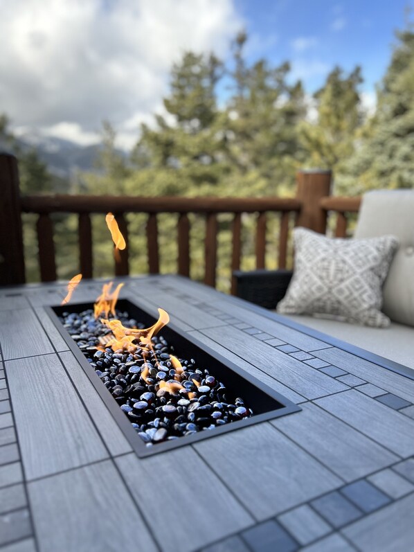 A rectangular fire feature with a wooden deck and a sofa with cushions. - NEW - A Place for Rest! (La Veta)