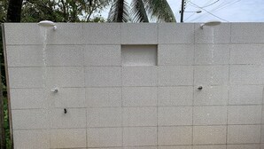 A large, textured wall with a small rectangular opening. - Casa D'Jhú (Vera Cruz)