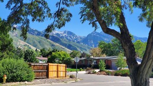 A residential area with a view of mountains, a wooden fence, and a house with a garage.