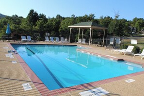 A swimming pool with lounge chairs and a gazebo.