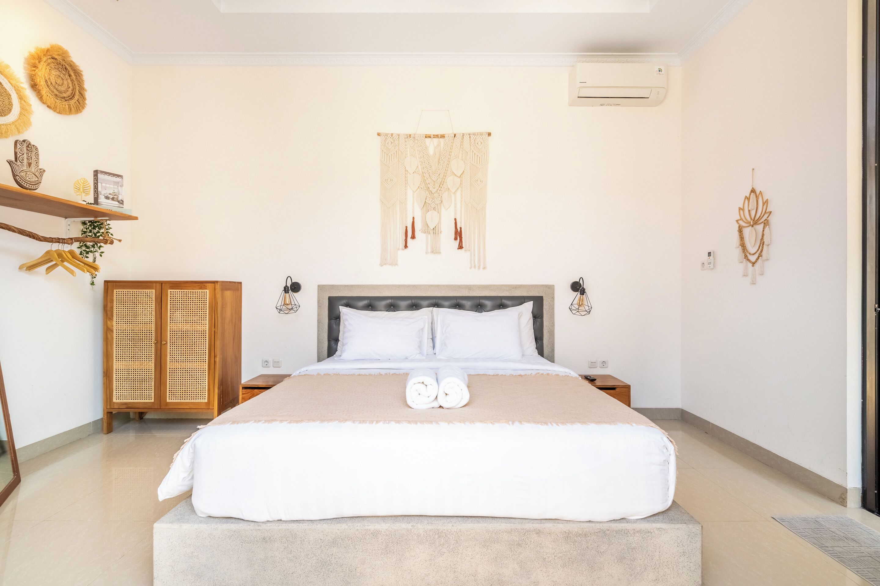Ein Schlafzimmer mit Bett, Nachttischen, einem Kleiderschrank und Wanddekorationen.