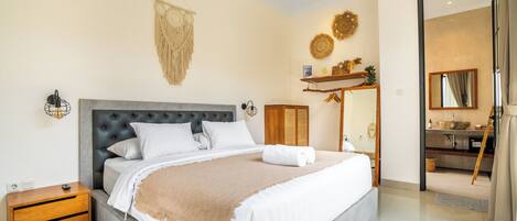 A modern bedroom with a large bed, bedside tables, a wardrobe, and a view into the bathroom.