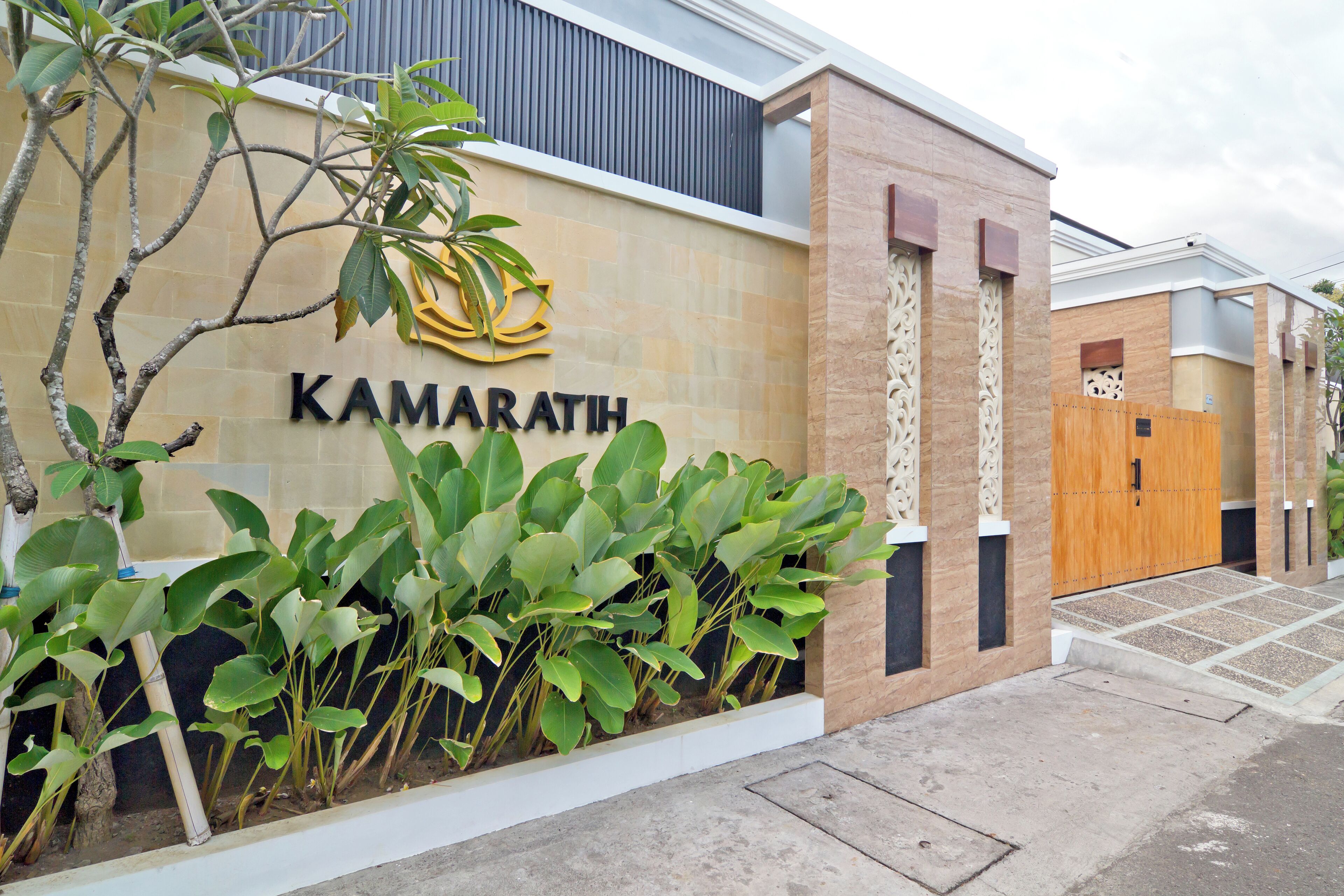 Un edificio con un letrero que dice "KAMARATH" y una puerta de madera.