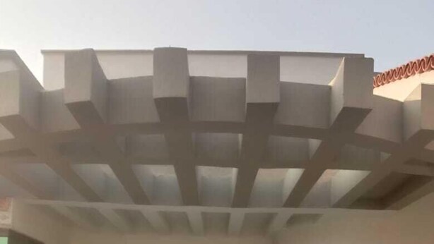 A building entrance with a wooden door, a window with a grid pattern, and a ceiling with a geometric design. - Impeccable 4-Bed Villa in Mirpur azad khasmir (Mirpur azad khasmir)