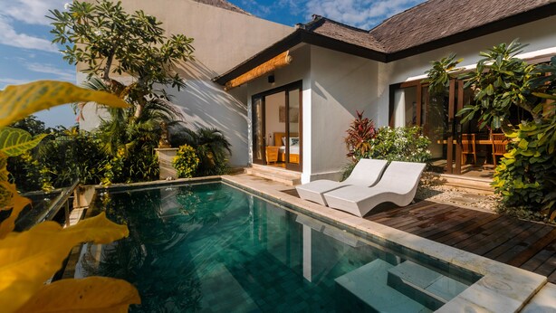 A modern house with a swimming pool, a wooden deck, and lush greenery. - Villa Jade (Ungasan)