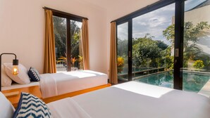 A hotel room with two beds, a large window, and a view of a swimming pool. - Villa Jade (Ungasan)