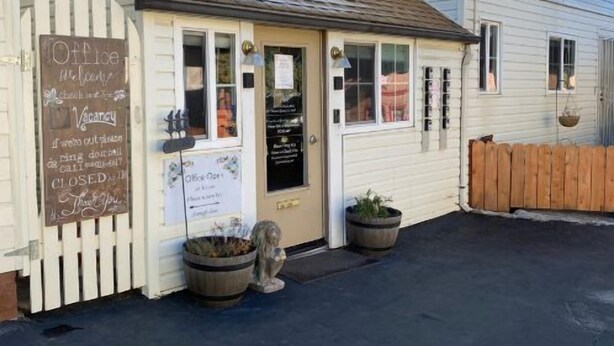 A small, single-story building with a white exterior and a brown roof. There is a sign on the door indicating it is a coffee shop. - Monte Bianco Inn (Mount Shasta)