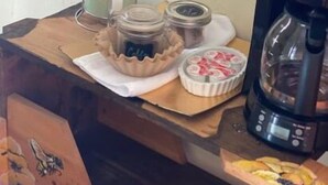 A kitchen counter with a coffee maker, a jar with a label, and a container with a lid. - Monte Bianco Inn (Mount Shasta)
