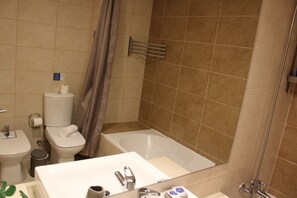 Un baño con inodoro, lavamanos y bañera.