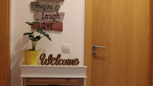 Une porte en bois avec une pancarte blanche indiquant « Bienvenue » au-dessus.