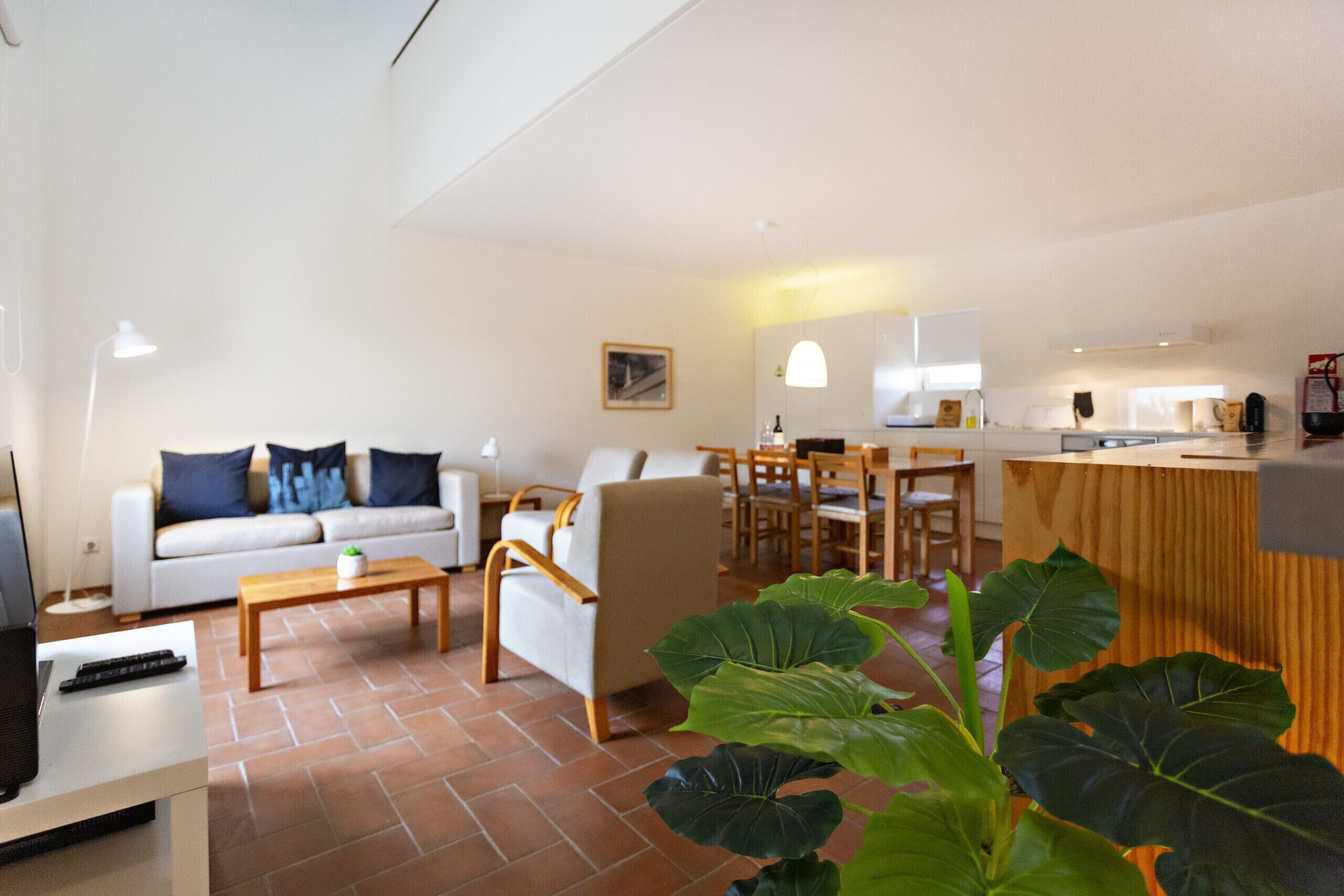 Ein modernes Wohnzimmer mit Sofa, Couchtisch und Essbereich.