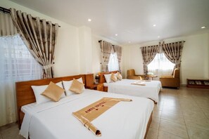Relax in a serene space with two single beds, a seating area, and a large window.