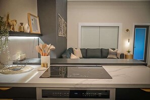Een moderne keuken met een geïntegreerd inductiefornuis, een digitaal display en een marmeren aanrecht.