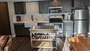 A modern kitchen with dark cabinets, a stainless steel refrigerator, a microwave, and a built-in oven. - Beautiful, Quiet Condo in Keystone! (Keystone)