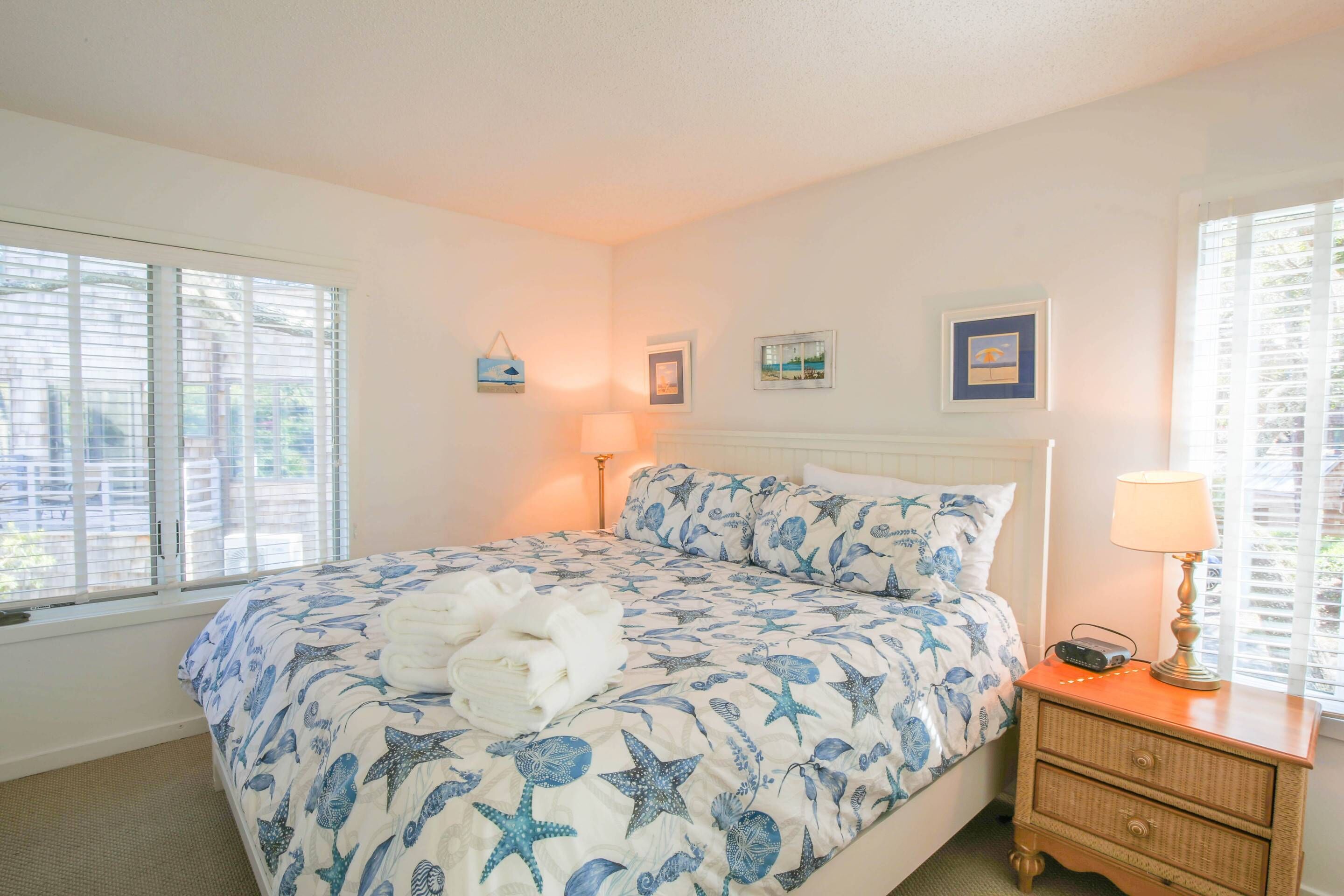 Une chambre à coucher avec un lit, une table de chevet et une fenêtre avec des stores.