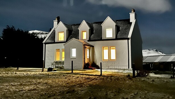 A two-story house with a sloped roof, multiple windows, and a visible chimney. - Hugh’s Highland Hideaway (Culnacnoc)