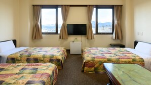 A hotel room with two beds, a TV, a small desk, and a view of the mountains. - Tabist Business Hotel Osamura (Sabae)