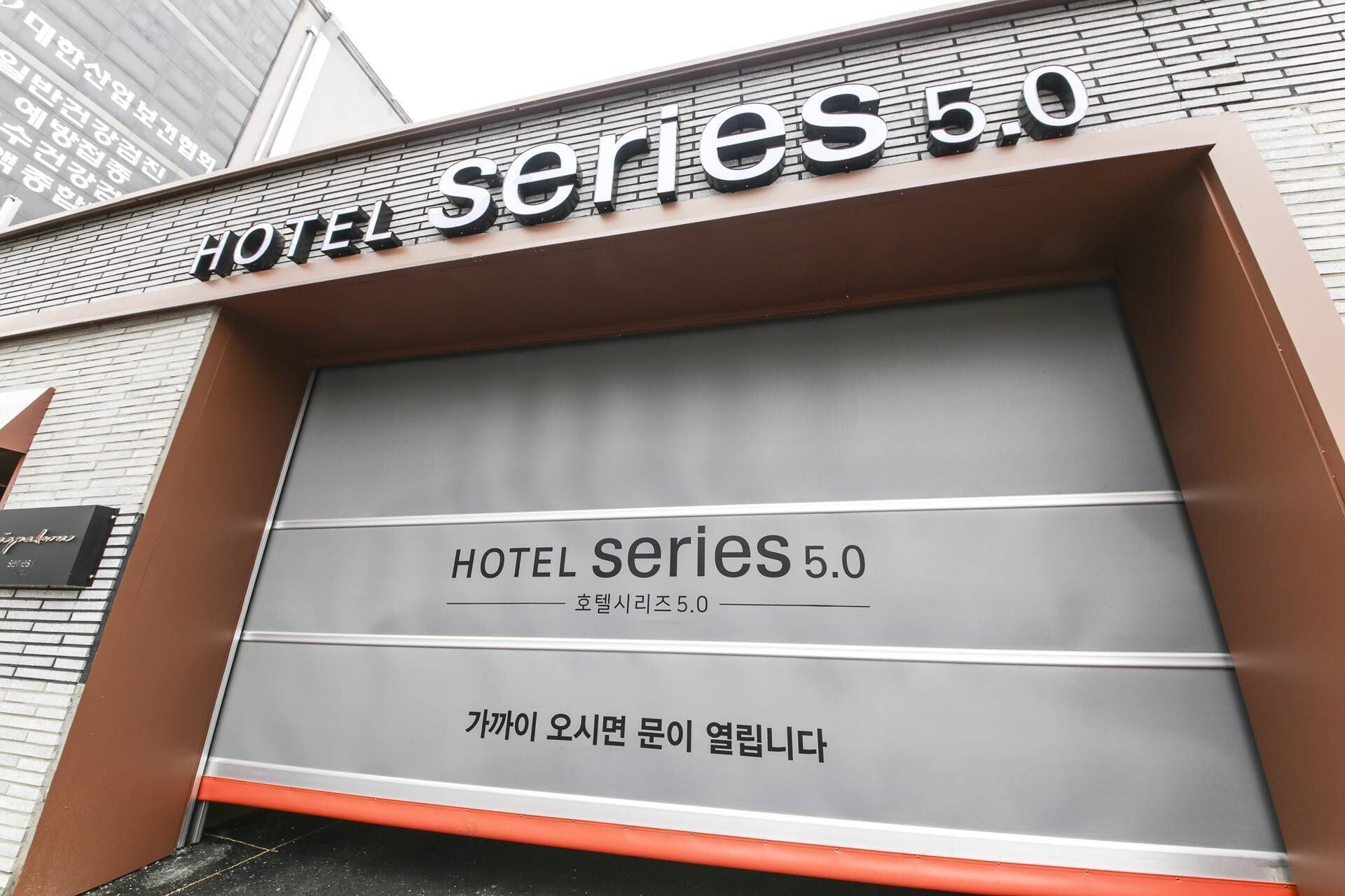 A hotel entrance with a large sign reading 'HOTEL SERIES 5.0'.