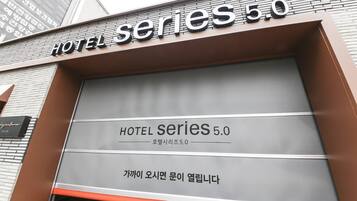 Entrada de um hotel com uma grande placa indicando 'HOTEL SERIES 5.0'.