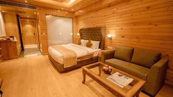 A wooden-paneled room with a bed, a sofa, and a coffee table.