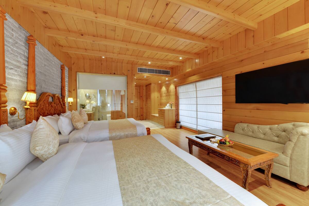A wooden interior with a bed, sofa, and a television.