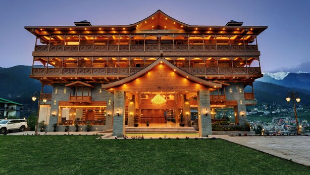 A multi-story wooden building with balconies and a large entrance.