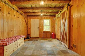 A wooden interior with a bench, a door, and a window.
