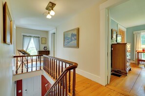 A wooden staircase with a railing leading to a second-floor landing.