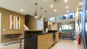 A modern kitchen with a central island, pendant lighting, and a view to the outdoors. - 1 Mile to Disney: Modern Townhouse in Magic 3114 (Kissimmee)