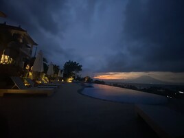Un resort con piscina, sillas de descanso y sombrillas.