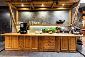 Enjoy a warm breakfast in this inviting kitchen area, complete with a coffee machine, fresh fruits, and a wooden island counter.