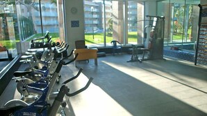 Un gimnasio con bicicletas estáticas, una banca y equipo de ejercicio.