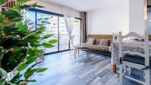 Een kamer met een bank, een tafeltje, een stoel en een bed.