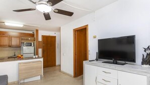 A compact living space with a kitchenette, a dining area, and a TV on a white cabinet. - Michelangelo by Interhome (Salou)