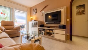 Ein Wohnzimmer mit Sofa, Fernseher und Unterhaltungseinheit.