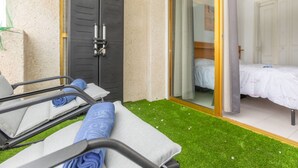 A room with a bed, a bathroom with a shower, and a balcony with artificial grass. - Catalunya 92 by Interhome (Salou)