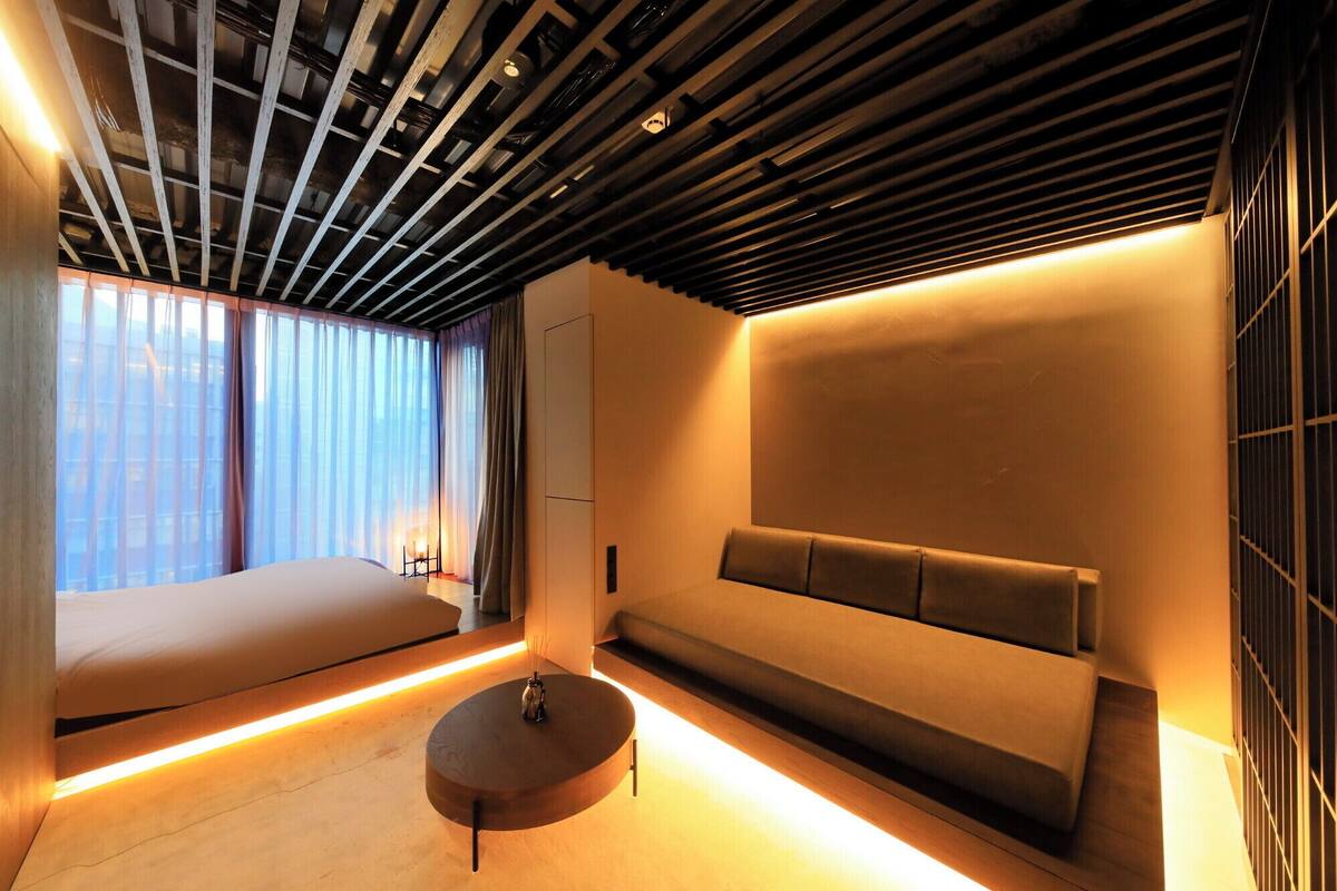 A modern room with a sofa, a round table, and a bench.