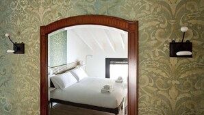 A bedroom with a bed, a mirror, and a nightstand with a lamp. - Italianway Easy - Caretto 4 - Toscanini (Milan)
