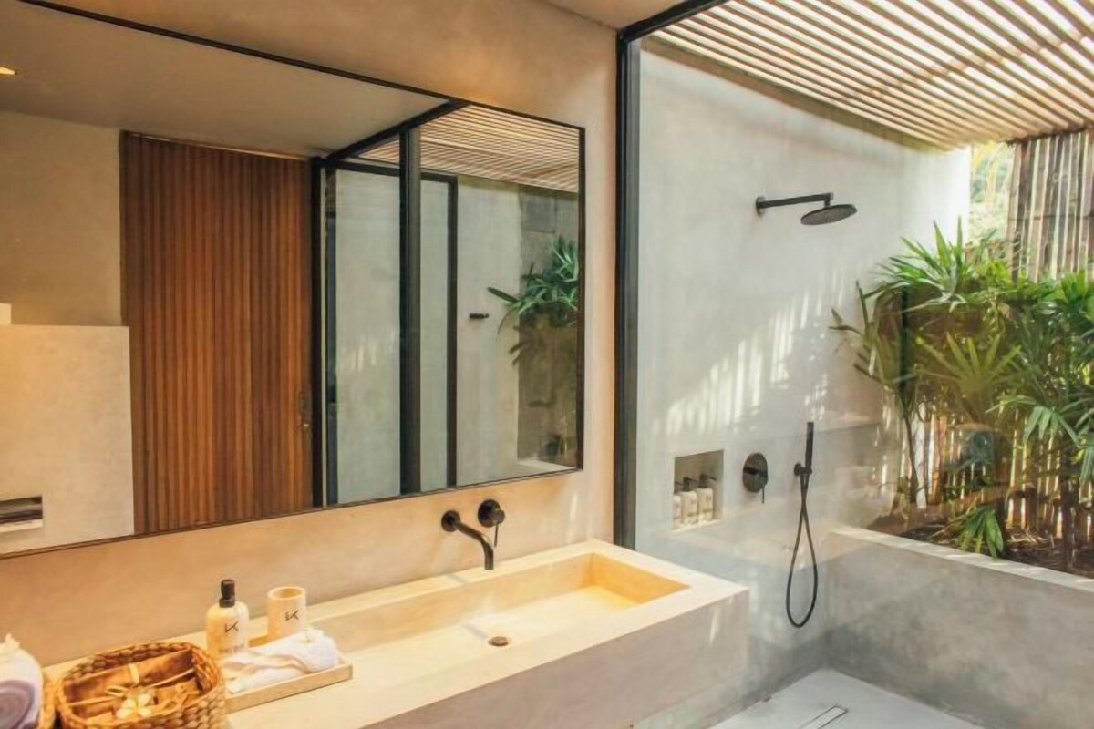 Un bagno moderno con uno specchio grande, una vasca e uno spazio doccia.