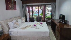 Une chambre d’hôtel avec un grand lit, une télévision et une vue sur une piscine et un espace extérieur.