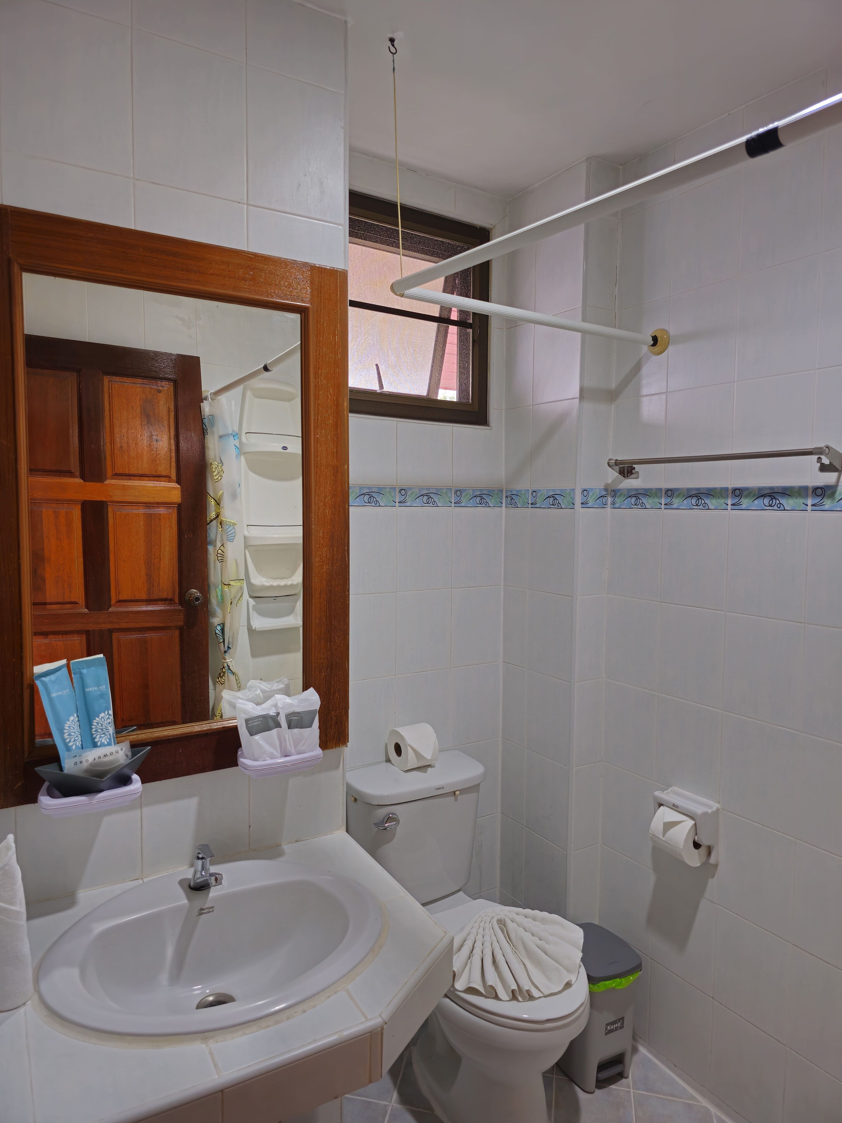 A bathroom with a sink, toilet, and mirror.