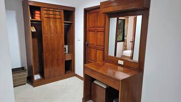 Un armario de madera con espejo y un pequeño escritorio.